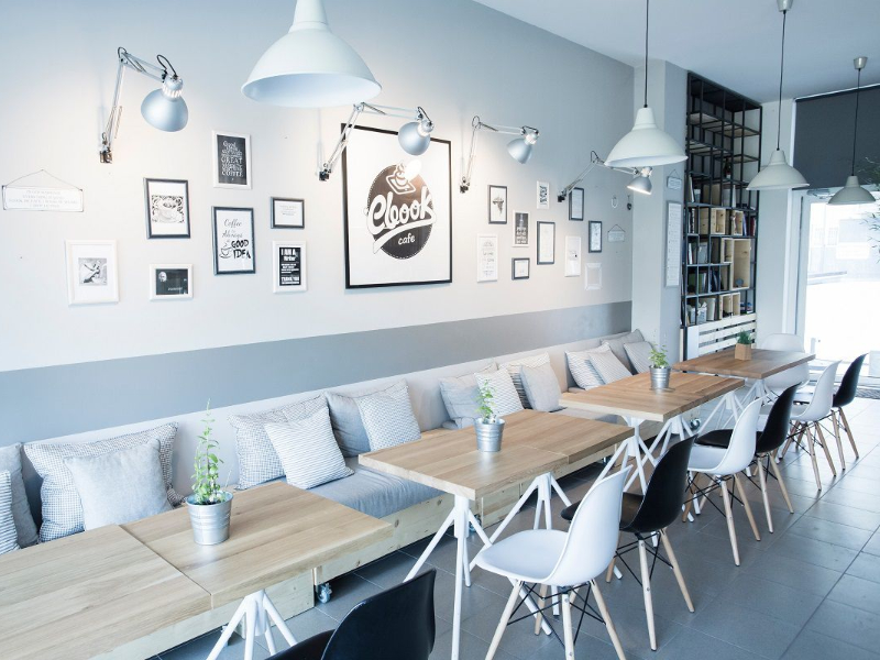 Không gian quán cafe 80m2 tối giản với băng ghế nệm dài và bàn ghế cafe chân gỗ
